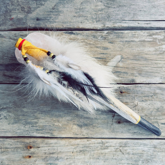 Détail d’un bâton chamanique autochtone peint à la main avec cuir d’orignal, fourrure véritable et plumes naturelles