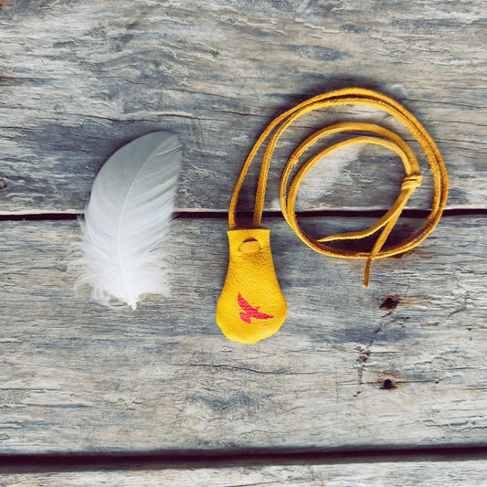 Petit sac de medecine en cuir d'orignal et aigle peint en rouge, il a une petite plumes blanche en décoration.  