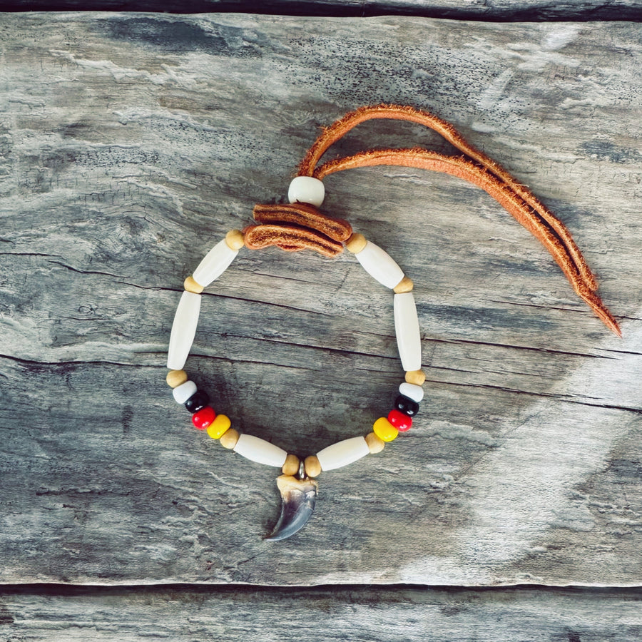 Bracelet autochtone avec véritable griffe de loup, perles d'os, perles de verre et cuir d'orignal, fabriqué à la main par un artisan Ilnu de Mashteuiatsh.