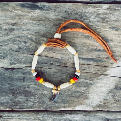 Bracelet autochtone avec véritable griffe de loup, perles d'os, perles de verre et cuir d'orignal, fabriqué à la main par un artisan Ilnu de Mashteuiatsh.