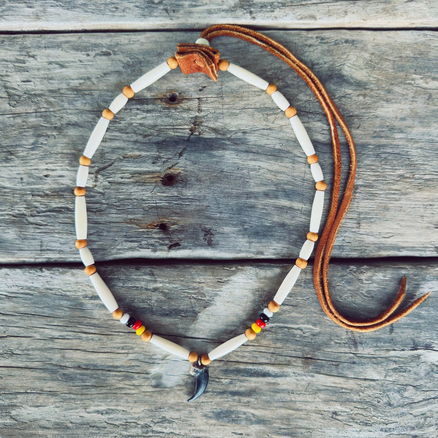 Bracelet roue de médecine Esprit du Loup avec véritable griffe de loup, perles d'os, perles de verre et cuir d'orignal, fabriqué à la main par un artisan Ilnu de Mashteuiatsh.