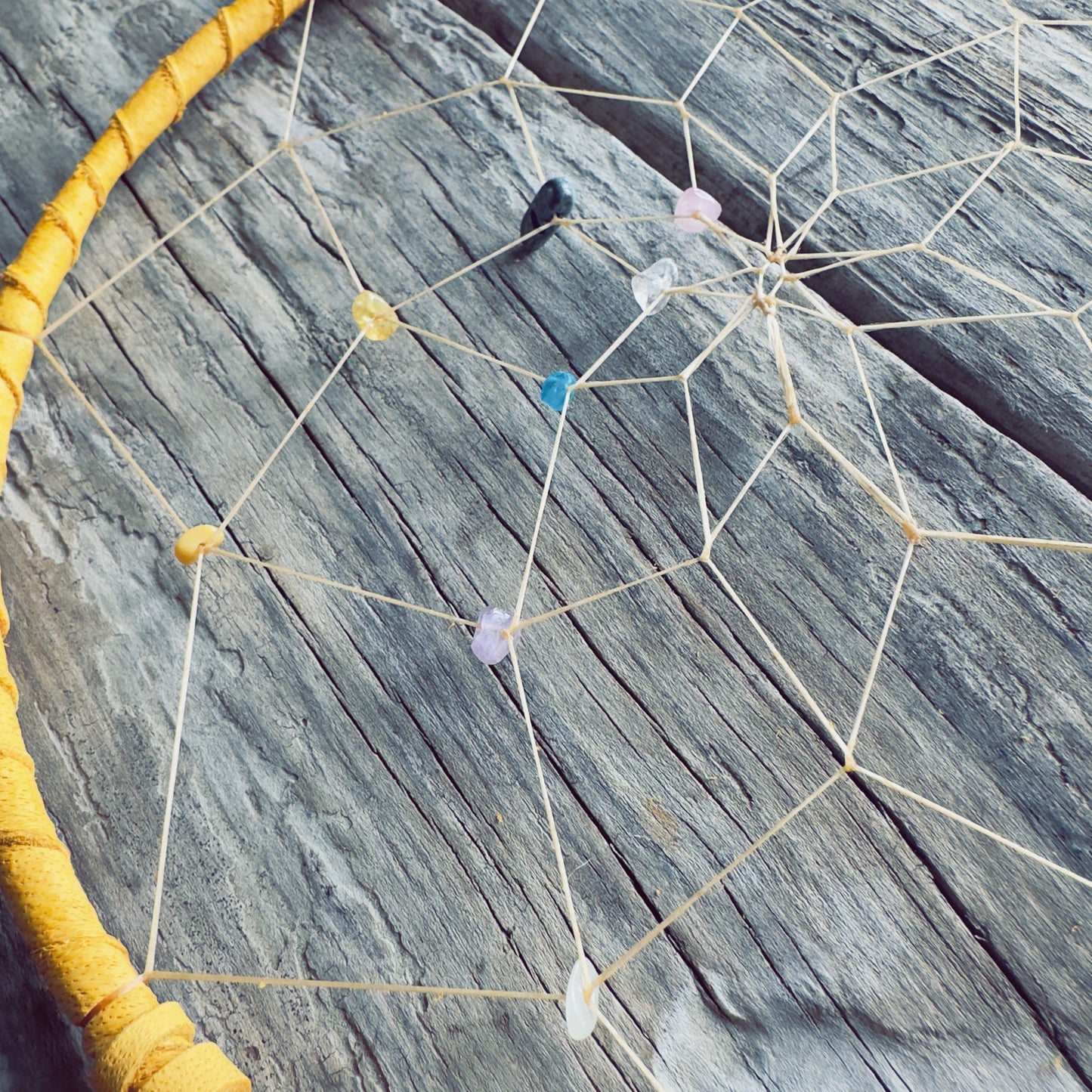 Détail de la toile du capteur de rêves avec pierres semi-précieuses.