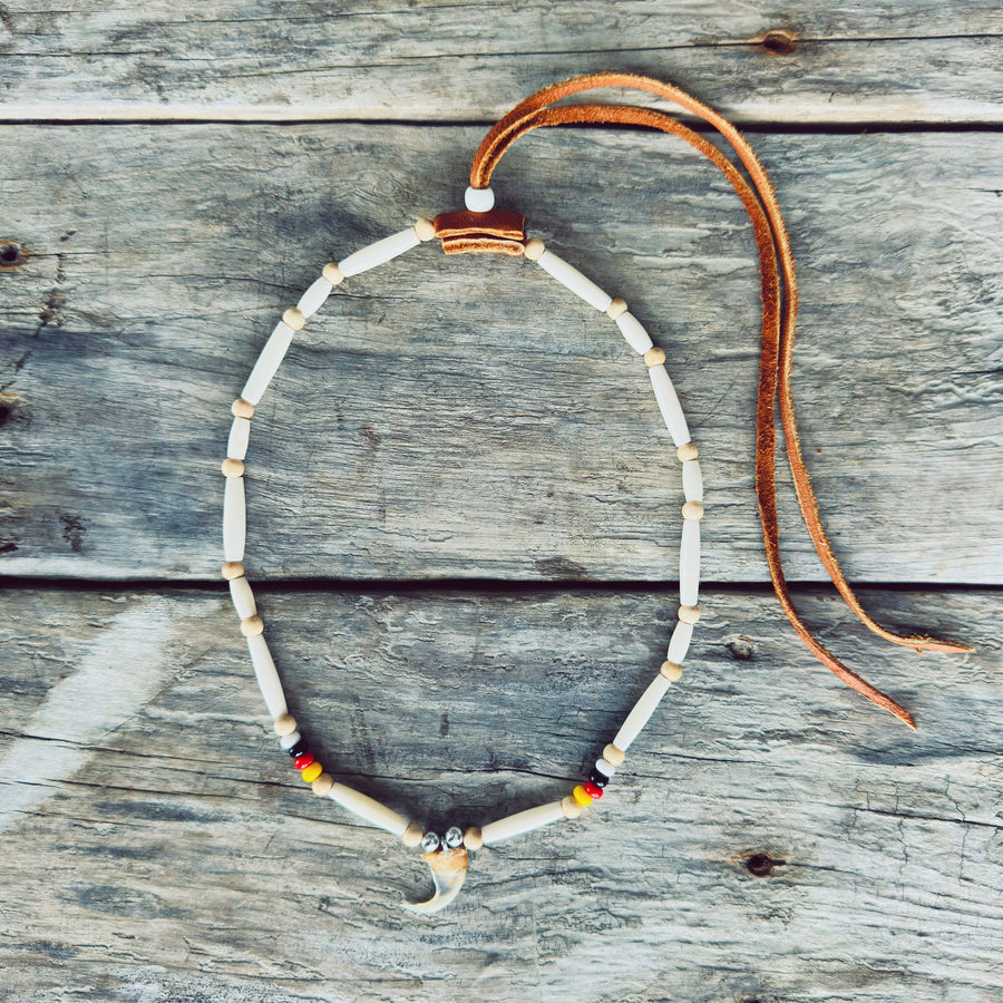 Collier autochtone en perles d'os avec véritable griffe de lynx et cuir d'orignal, fabriqué à la main par un artisan Ilnu de Mashteuiatsh.
