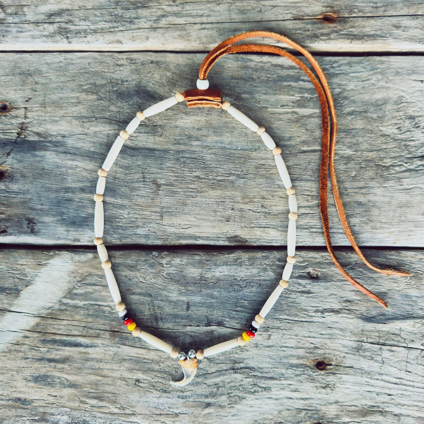 Collier autochtone en perles d'os avec véritable griffe de lynx et cuir d'orignal, fabriqué à la main par un artisan Ilnu de Mashteuiatsh.