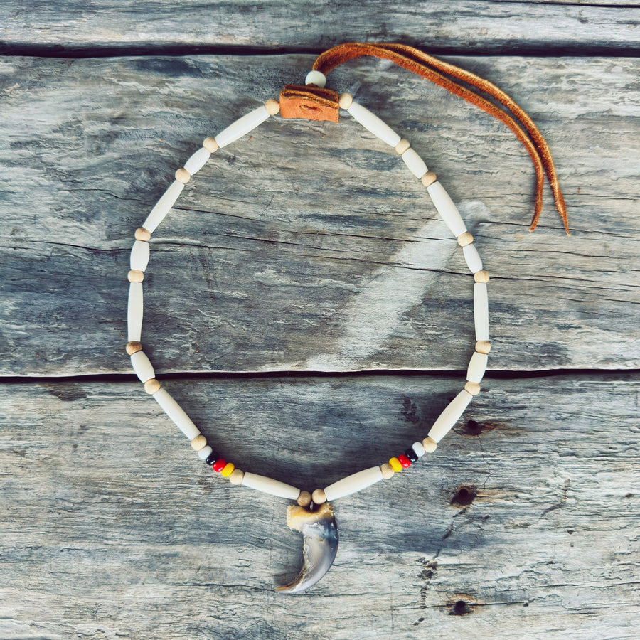 Collier autochtone avec véritable griffe d'ours, roue de médecine, perles d'os et cuir d'orignal, fabriqué à la main par un artisan Ilnu de Mashteuiatsh.