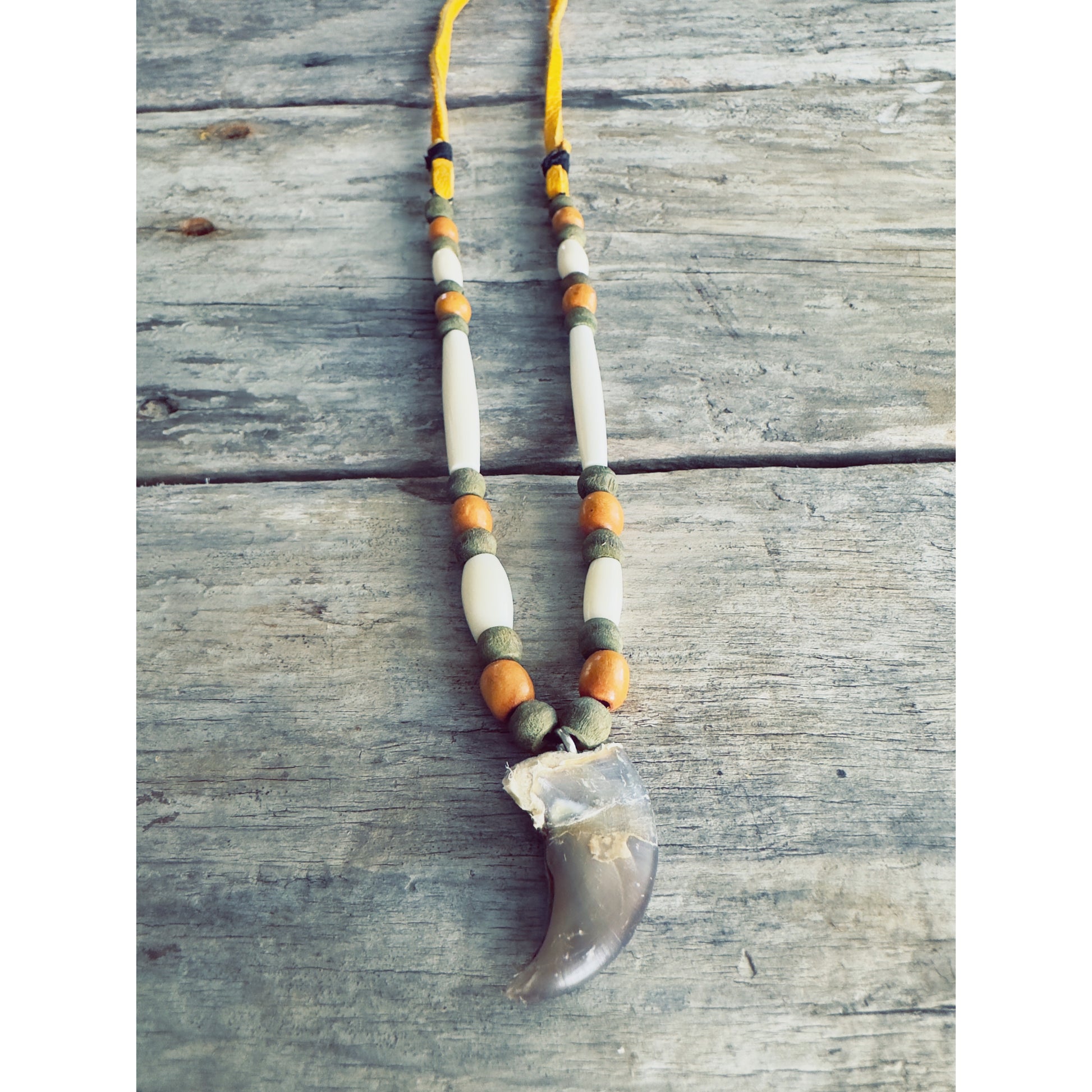 Collier en griffe d’ours inspiré des animaux totems, rappelant la connexion entre l’humain et la nature.