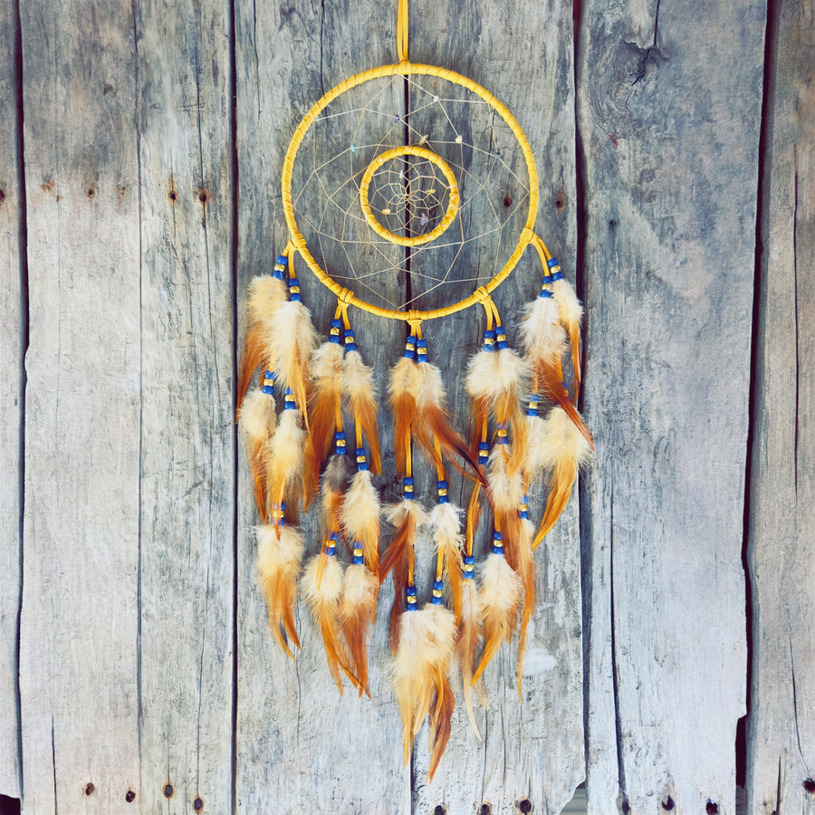 Artisanat autochtone : grand capteur de rêves de 8 pouces en cuir jaune avec double cerceau, perles bleu royal et blanches, plumes naturelles tachetées sur fond de bois