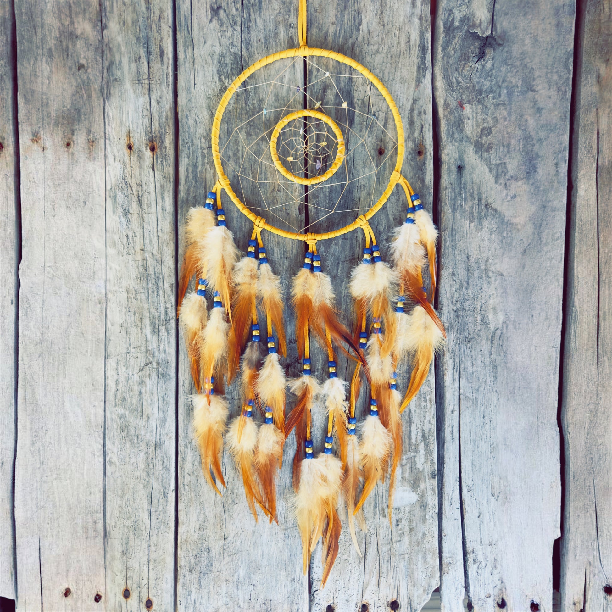 Artisanat autochtone : grand capteur de rêves de 8 pouces en cuir jaune avec double cerceau, perles bleu royal et blanches, plumes naturelles tachetées sur fond de bois
