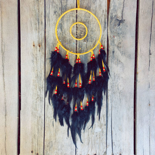 Artisanat autochtone : grand capteur de rêves de 8 pouces en cuir ocre jaune avec double cerceau, perles rouges et or, longues plumes noires sur fond de bois.