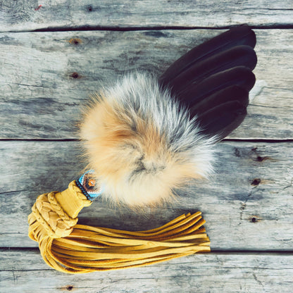 Smudge fan en véritable fourrure de renard roux avec plumes naturelles, fabriqué à la main pour les rituels de purification, symbole d'ancrage instinctif et de clarté intérieure par un artisan Ilnu.